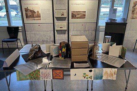 Ein Tisch in der Mitte des Ausstellungsraumes, voll mit Modellen und Bastelsachen